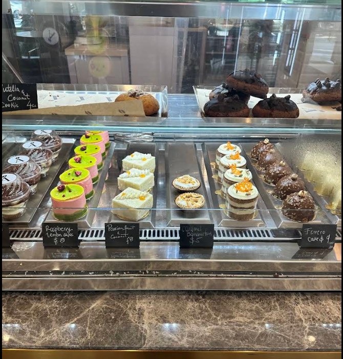 Dessert case at Allora Cayman with cakes, tarts and cookies