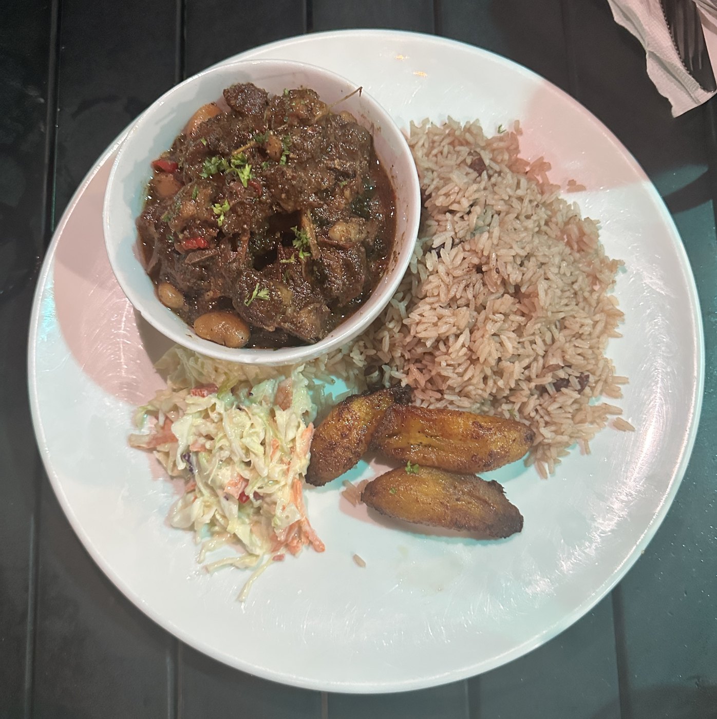Cayman Cabana oxtails with rice and peas, slaw, and fried plantain