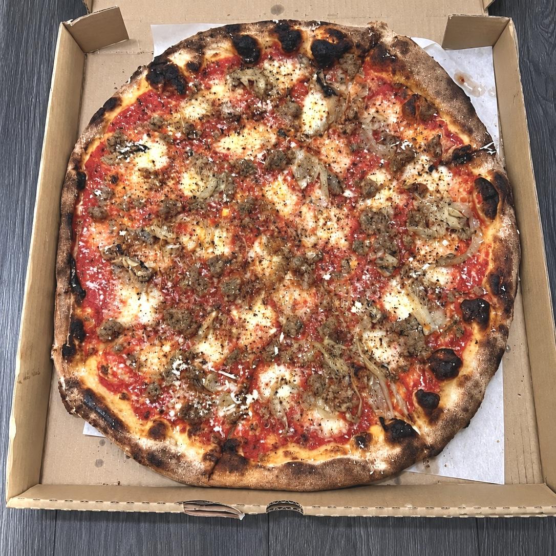 18-inch Sausage and Fennel pizza with charred crust in an open box from North of Brooklyn Pizzeria, Queen Street West, Toronto